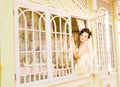 Young beautiful bride waits for groom near the window. Beautiful Bride lit by sunlight. beautiful young bride waiting