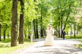 Young beautiful bride waits for groom in the spring park