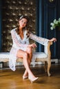 Young beautiful bride in white negligee preparing to wedding ceremony Royalty Free Stock Photo