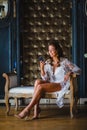 Young beautiful bride in white negligee watching a message in her smartphone Royalty Free Stock Photo