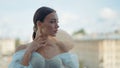 Young beautiful bride in a white wedding dress standing on a balcony on blurred city background. Action. Elegant woman Royalty Free Stock Photo