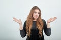 Girl brown haired in black dress over isolated white background shows emotions Royalty Free Stock Photo