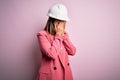 Young beautiful brunette architect woman wearing safety helmet over pink background with sad expression covering face with hands Royalty Free Stock Photo