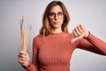 Young beautiful brunette artist woman holding painter brushes over white background with angry face, negative sign showing dislike Royalty Free Stock Photo