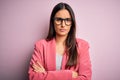 Young beautiful brunette businesswoman wearing jacket and glasses over pink background skeptic and nervous, disapproving Royalty Free Stock Photo