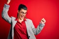 Young beautiful brunette businesswoman wearing jacket and glasses over red background Dancing happy and cheerful, smiling moving Royalty Free Stock Photo