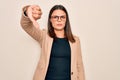 Young beautiful brunette businesswoman wearing jacket and glasses over white background looking unhappy and angry showing Royalty Free Stock Photo