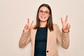 Young beautiful brunette businesswoman wearing jacket and glasses over white background smiling looking to the camera showing Royalty Free Stock Photo