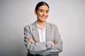 Young beautiful brunette businesswoman wearing jacket standing over white background happy face smiling with crossed arms looking Royalty Free Stock Photo