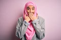 Young beautiful brunette businesswoman wearing pink muslim hijab and business jacket shocked covering mouth with hands for mistake Royalty Free Stock Photo