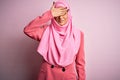 Young beautiful brunette businesswoman wearing pink muslim hijab and business jacket smiling and laughing with hand on face Royalty Free Stock Photo