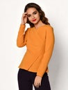 Young beautiful brunette curly woman posing in new casual orange blouse sweater Royalty Free Stock Photo