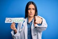 Young beautiful brunette doctor woman wearing coat holding paper with go vegan message pointing with finger to the camera and to Royalty Free Stock Photo