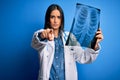 Young beautiful brunette doctor woman wearing stethoscope holding chest xray pointing with finger to the camera and to you, hand Royalty Free Stock Photo