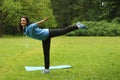 Young beautiful brunette doing swallow exercise in summer morning park Royalty Free Stock Photo