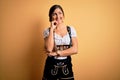 Young beautiful brunette german woman celebrating Octoberfest wearing traditional dress with hand on chin thinking about question,