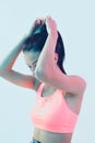Young beautiful brunette girl adjusts her hair in neon studio light, everyday beauty routine concept Royalty Free Stock Photo