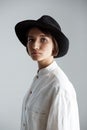 Young beautiful brunette girl in black hat over white background. Royalty Free Stock Photo