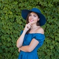 Young and beautiful brunette girl in dress and hat walking outdoor in the park. Nice, France. Summer vacation, traveling Royalty Free Stock Photo