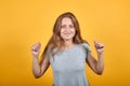 Brunette girl in gray t-shirt over isolated orange background shows emotions Royalty Free Stock Photo