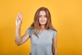 Brunette girl in gray t-shirt over isolated orange background shows emotions Royalty Free Stock Photo