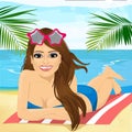 Young beautiful brunette girl lying on a beach towel Royalty Free Stock Photo