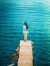 Young beautiful brunette girl on the pier of Preveli Beach Palm Beach, Preveli, Crete Greece.