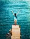 Young beautiful brunette girl on the pier of Preveli Beach Palm