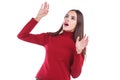 A frightened girl looks up and hides her hands on a white isolated background