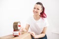 Young beautiful brunette girl in a white t-shirt packs cardboard boxes with a dispenser and adhesive scotch adhesive Royalty Free Stock Photo