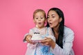 Young beautiful brunette mother and her little daughter are celebrating a birthday Royalty Free Stock Photo