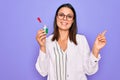 Young beautiful brunette scientist woman wearing coat and glasses holding test tube Smiling happy pointing with hand and finger to Royalty Free Stock Photo