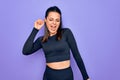 Young beautiful brunette sporty woman wearing casual sportswear over purple background Dancing happy and cheerful, smiling moving Royalty Free Stock Photo