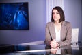 Young beautiful brunette television announcer at studio during live broadcasting.Female TV director at editor in studio.