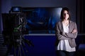 Young beautiful brunette television announcer at studio during live broadcasting.Female TV director at editor in studio. Royalty Free Stock Photo