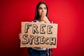 Young beautiful brunette woman asking for rights holding banner with free speech message serious face thinking about question, Royalty Free Stock Photo