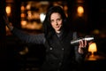 Young beautiful brunette woman bartender stands with shaker in her hand.