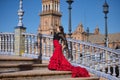 Young, beautiful, brunette woman in black shirt and red skirt, dancing flamenco on the stairs of a beautiful bridge in Spain Royalty Free Stock Photo