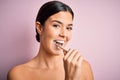 Young beautiful brunette woman brushing her teeth using tooth brush and oral paste, cleaning teeth and tongue as healthy health Royalty Free Stock Photo