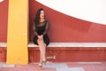 Young, beautiful brunette woman is dressed elegantly in a black dress with transparencies and fancy earrings. The girl is sitting Royalty Free Stock Photo