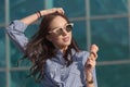 Young, beautiful brunette woman eating pink ice cream in a waffle horn. She`s in a good mood She wears glasses with dark glasses, Royalty Free Stock Photo