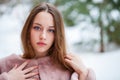 Young beautiful brunette woman in fur coat posing on winter park Royalty Free Stock Photo