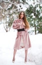 Young beautiful brunette woman in fur coat posing on winter park Royalty Free Stock Photo