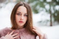 Young beautiful brunette woman in fur coat posing on winter park Royalty Free Stock Photo