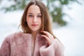 Young beautiful brunette woman in fur coat posing on winter park Royalty Free Stock Photo
