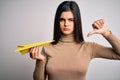 Young beautiful brunette woman holding paper airplane over isolated white background with angry face, negative sign showing Royalty Free Stock Photo