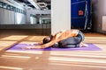 Young beautiful brunette woman making stretching exercises in a light studio. Well being, wellness concept. Yoga balasana pose Royalty Free Stock Photo