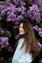 Young beautiful brunette woman is smelling lilac flower blossom in spring time Royalty Free Stock Photo