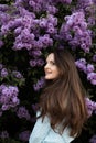 Young beautiful brunette woman is smelling lilac flower blossom in spring time Royalty Free Stock Photo