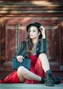 Young beautiful brunette woman with red short dress and black hat posing sensual in vintage scenery. Romantic mysterious lady Royalty Free Stock Photo